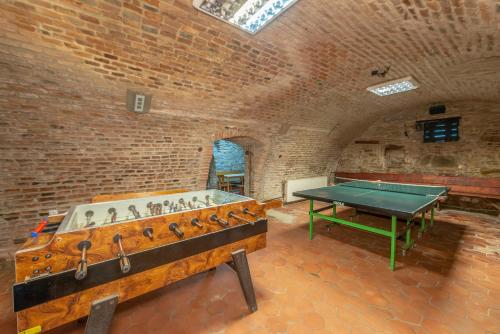 uma mesa de pingue-pongue num quarto com uma parede de tijolos em Burg Hostel Sighisoara em Sighişoara