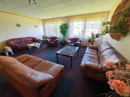 a living room with brown leather couches and a table at Gabriel in Maardu