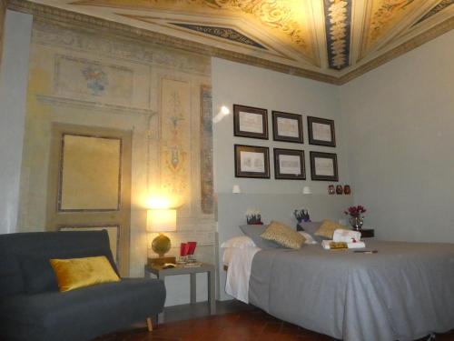 ein Schlafzimmer mit einem Bett, einem Stuhl und einer Kassettendecke in der Unterkunft LO studiO B&B in Pistoia