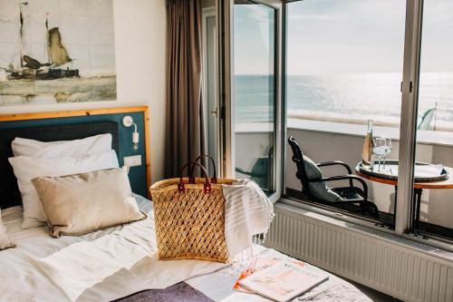 a bedroom with a bed with a view of the ocean at Boulevard 5 in Zandvoort