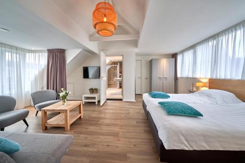 a bedroom with two beds and a living room at Apartments Four Seasons Voorstraat in Egmond aan Zee