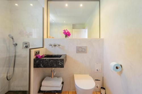La salle de bains est pourvue d'un lavabo, de toilettes et d'un miroir. dans l'établissement Villa Blanca Santa Eulalia, à Santa Eulària des Riu