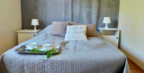 taca z jedzeniem na łóżku z dwoma kubkami w obiekcie Apartament Gościnny Zakątek w mieście Sumowo