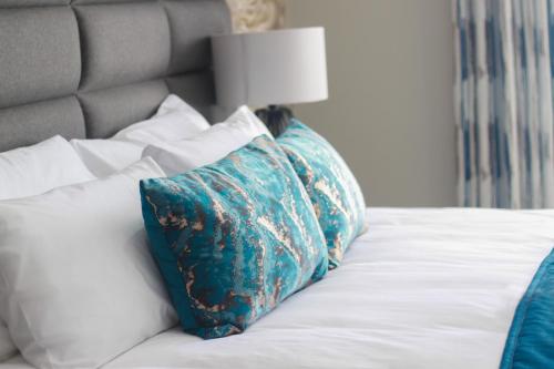 a bed with two pillows and a lamp on it at The Cato Suites Hotel in Durban