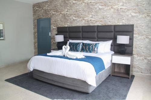 Un pat sau paturi într-o cameră la The Cato Suites Hotel