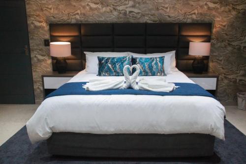 a bedroom with a large bed with a bow on it at The Cato Suites Hotel in Durban