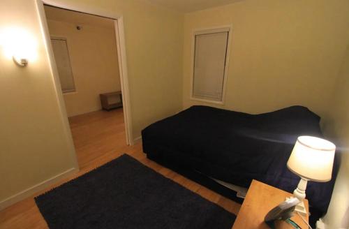 a bedroom with a bed and a table with a lamp at Superp South End Apartment in Burlington
