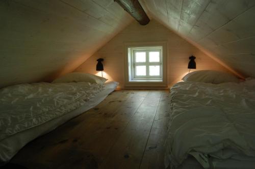 a attic bedroom with two beds and a window at Lycka in Torestorp