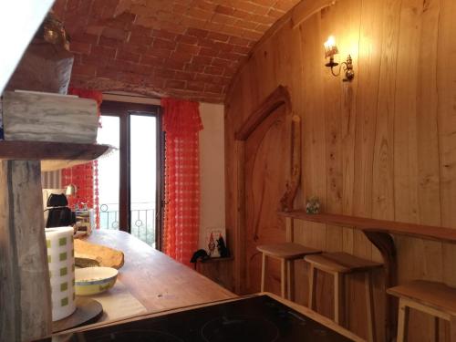 a kitchen with wooden walls and a table with stools at Bed and breakfast Ca du 5 in Tovo San Giacomo