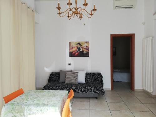 1 dormitorio con cama y lámpara de araña en Central Apartment - Residenza Battistessa, en Caserta