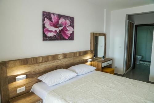a bedroom with a bed with a wooden headboard at BUZUKU Apartments Liman (Mediterraneo) in Ulcinj