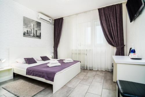 キーウにあるSkyHome Mini-hotelのベッドルーム1室(紫のシーツが敷かれたベッド1台、窓付)