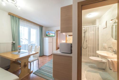 ein Bad mit einem Waschbecken, einem WC und einem Schreibtisch in der Unterkunft Residence Ortlerhof in Prad am Stilfserjoch