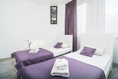 two beds in a hotel room with towels on them at SkyHome Mini-hotel in Kyiv