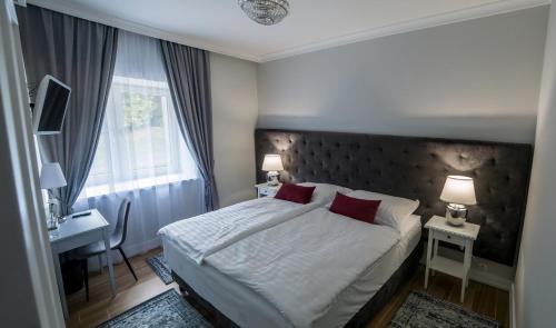 ein Schlafzimmer mit Bett, Schreibtisch und Fenster in der Unterkunft AM Hotel Kaštieľ & Restaurant in Rimavská Sobota