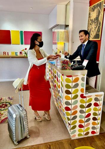 a man and a woman are standing at a counter at Hôtel Brimer Cannes in Cannes