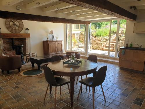 uma sala de estar com uma mesa e cadeiras e um piano em Gite La Grange de Jeanne em Rancon