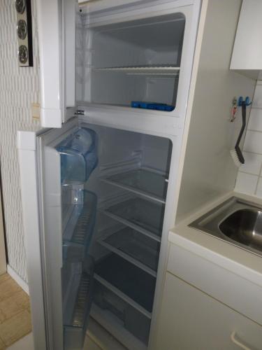 an empty refrigerator with its door open in a kitchen at Gabbiano De witte meeuw in Koksijde