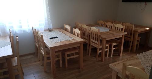 a dining room with wooden tables and chairs at Na Zakręcie in Ochotnica Górna