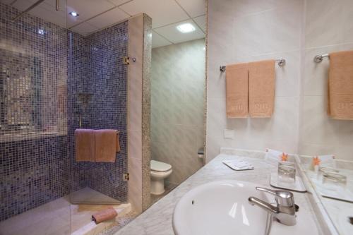 Un baño con lavabo, inodoro y ducha. en Hotel Riu Nautilus - Adults Only, en Torremolinos