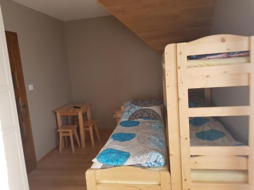 a bedroom with two bunk beds and a table at Na Zakręcie in Ochotnica Górna