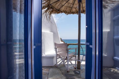 a room with a table and a chair and the ocean at Κymanemi Folegandros in Agali
