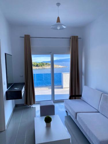 a living room with a couch and a view of the ocean at Fabeno Villa in Sarandë