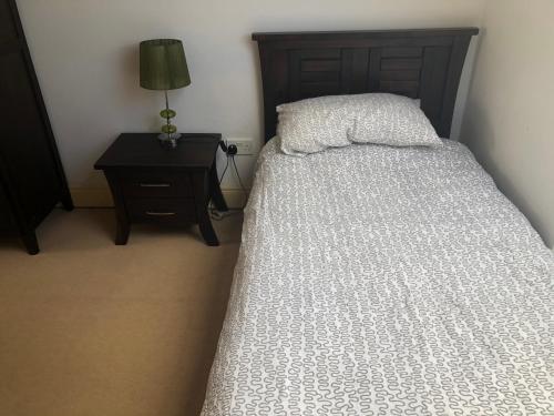 a bedroom with a bed and a table with a lamp at Letterfrack Farm Lodge house in Letterfrack village Connemara in Letterfrack