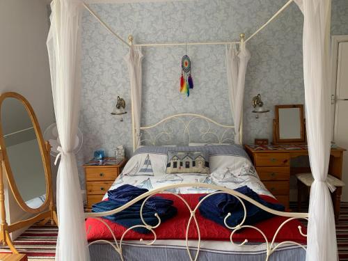 a bedroom with a bed with a canopy at The Lyndsay Guest House in Skegness