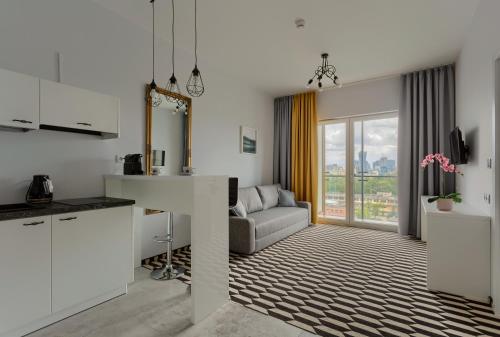 kuchnia i salon z kanapą i stołem w obiekcie Apartamenty Prymasa Residence w Warszawie