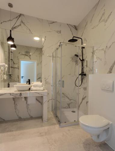 a bathroom with a shower and a toilet and a sink at Apartamenty Prymasa Residence in Warsaw