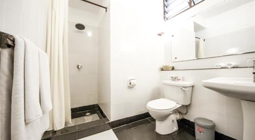 uma casa de banho branca com um WC e um lavatório em Papillon Lagoon Reef Hotel em Diani Beach