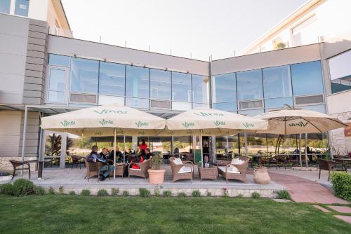 a patio with chairs and umbrellas in front of a building at Penzion Troja in Lipany