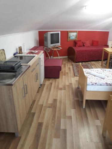 a kitchen and living room with a red couch at Apartments Emir in Tuzla