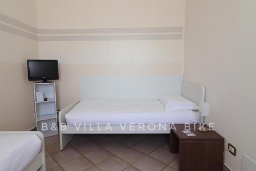 a small bedroom with a bed and a tv at B&B Villa Verona Bike in Buttapietra