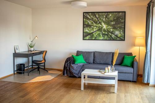 ein Wohnzimmer mit einem Sofa und einem Tisch in der Unterkunft BoardingHouse Neuburg in Neuburg an der Donau
