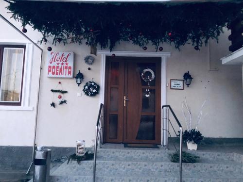 a house with a wooden door and stairs in front of it at Hotel Poenita in Sighişoara