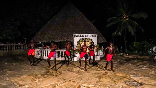 a group of people standing in front of a sign at Papillon Lagoon Reef Hotel in Diani Beach
