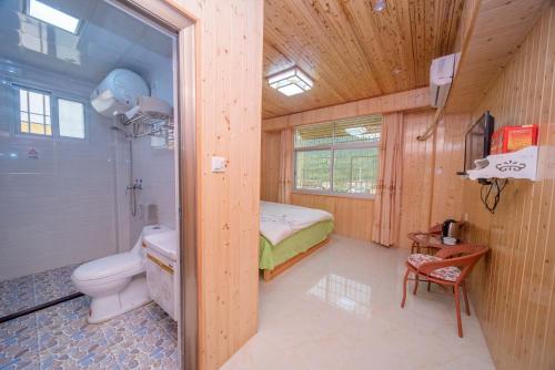 łazienka z toaletą i łóżko w pokoju w obiekcie Nanjing Yunshuiyao Haixi Inn Dashuiche w mieście Nanjing