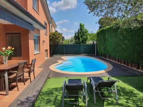 a swimming pool in a backyard with chairs and a table at Nice Home in Borgoñá