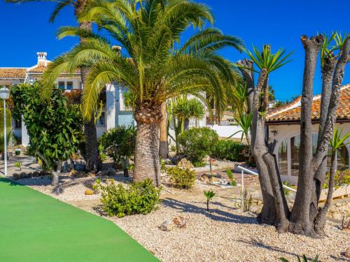 een palmboom voor een huis met een groen gazon bij Holiday Home La Camarrocha by Interhome in Moraira