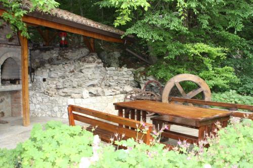 two wooden benches and a table in a garden at Joya Park Hotel in Golden Sands