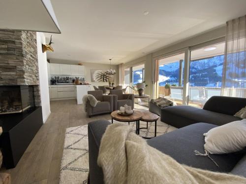 una sala de estar con sofás y una sala de estar con montañas. en Apartment Alpenrose by Interhome, en Adelboden