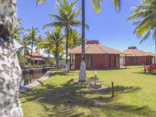 a house with palm trees in front of a yard at Pousada E Restaurante Doce Desejo in Ilhéus