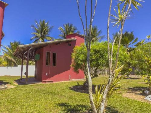 a red house in a yard with palm trees at Pousada E Restaurante Doce Desejo in Ilhéus