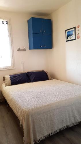 - une chambre avec un lit doté de placards bleus et une fenêtre dans l'établissement MARINA LE BARCARES, au Barcarès