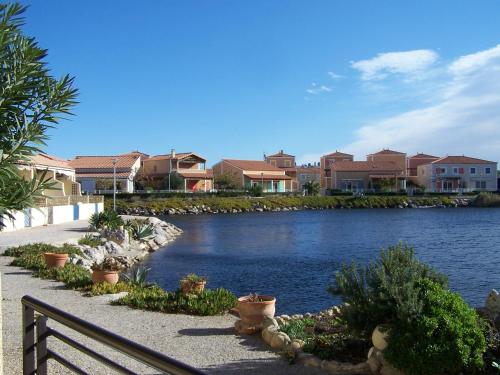 une masse d'eau avec des maisons en arrière-plan dans l'établissement MARINA LE BARCARES, au Barcarès