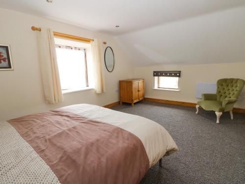 a bedroom with a bed and a chair and a window at Lavender Lodge in Hull