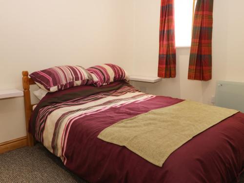 a bed with two pillows and a blanket in a bedroom at Daisy Nook in Hull