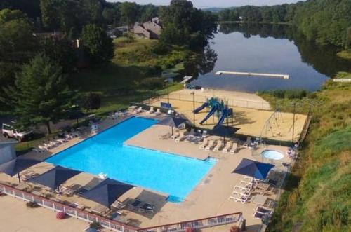 an overhead view of a large swimming pool next to a lake at Saw Creek Cabin - Regent Hilltop in Bushkill